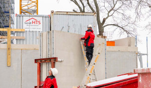 Montage der massiven Betonfertigteile für das fünfte Obergeschoss – präzise Arbeit im Team.