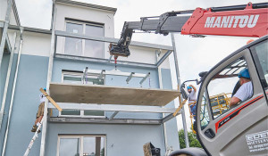 Mit viel Präzision wird die Balkonplatte aus Carbonbeton an der richtigen Stelle positioniert...
